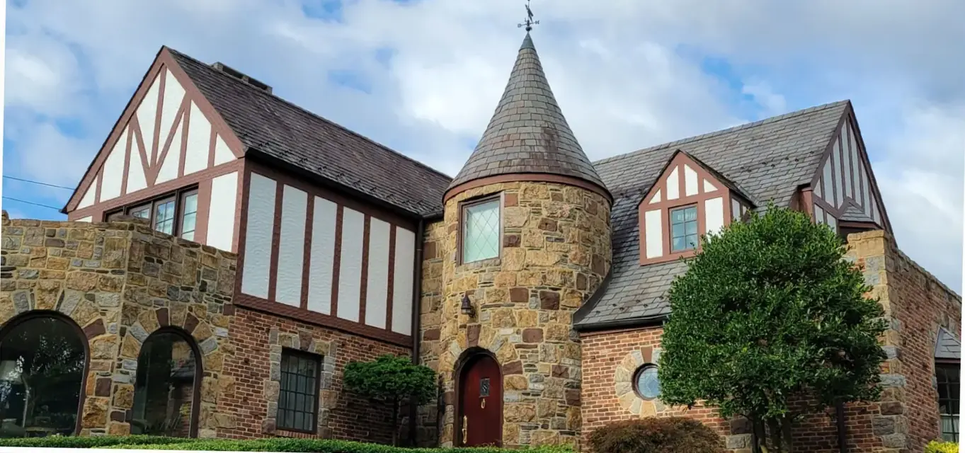 Stone Tudor with a slate turret in Manhasset before slate cleaning