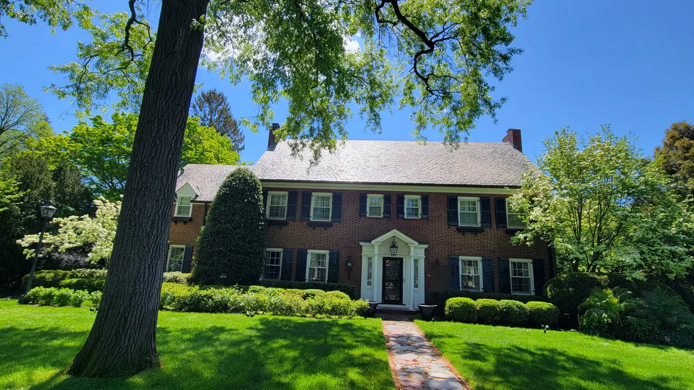 Brick Georgian under a big old tree in Old Westbury after slate cleaning