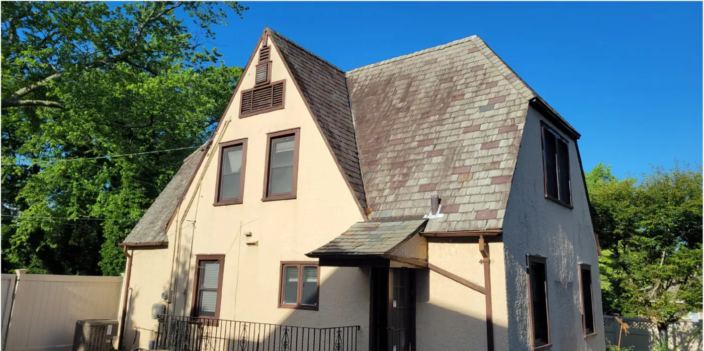 Stucco Tudor with steep gables in Rockville Centre before slate cleaning